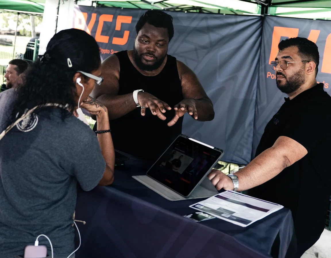 Trois personnes autour d&rsquo;une tablette, lors d&rsquo;un échange sur un stand